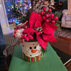 Festive centerpiece artificial Christmas floral arrangement in a snowman pot.